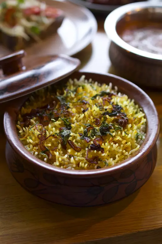 Saffron biryani steaming as the seal is broken